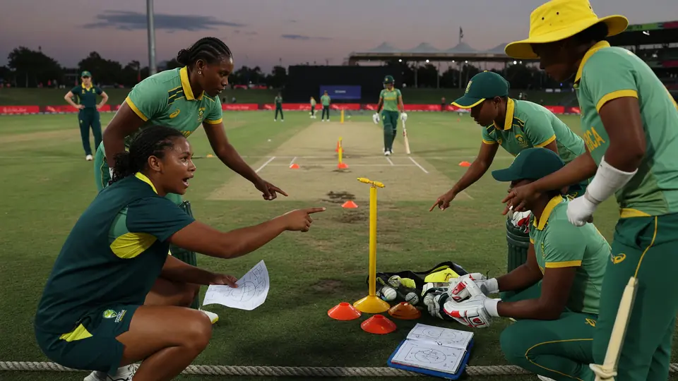 Medium tactical view of fielders and team interaction during a women's T20 powerplay